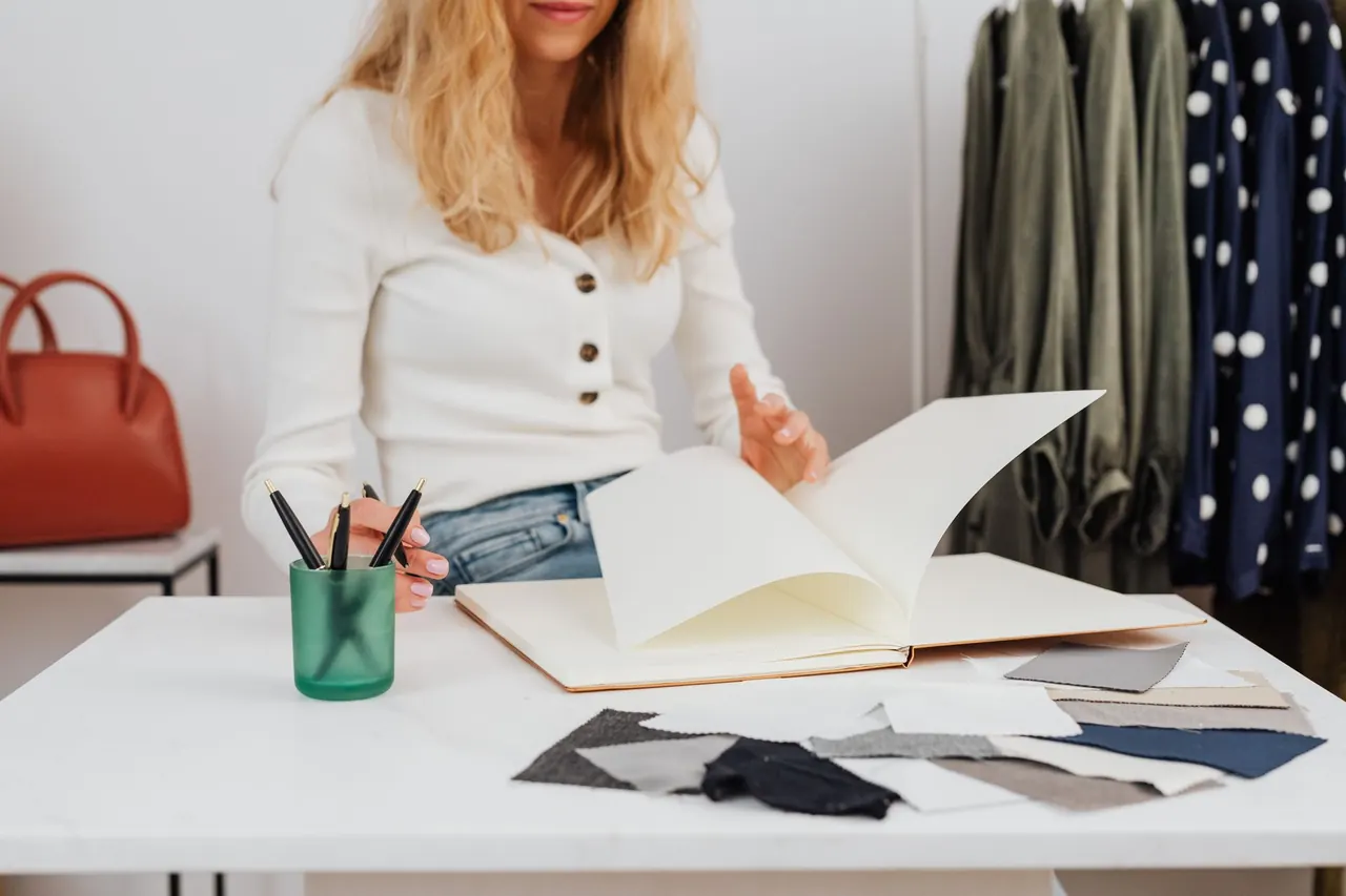 Designer reviewing textile samples and notes in a studio